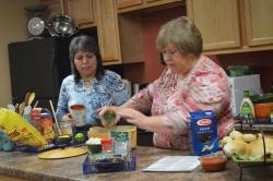 Image of Carol Calderon assists Connie Moyers in making One Pot Basil Pasta recipe